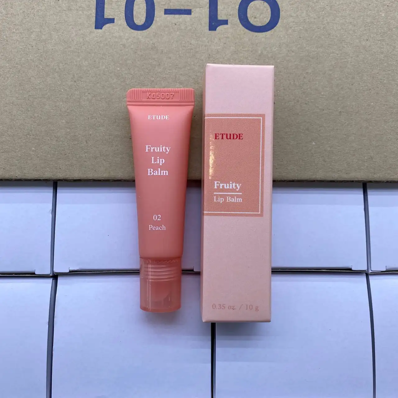 An lip balm flexible plastic packaging designed for portability and frequent use in the shade Watermelon. Its compact form and squeeze mechanism demonstrate how material can support convenience and accessibility.